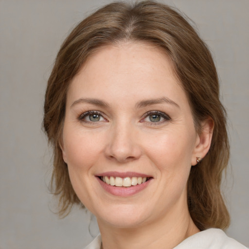 Joyful white young-adult female with medium  brown hair and green eyes