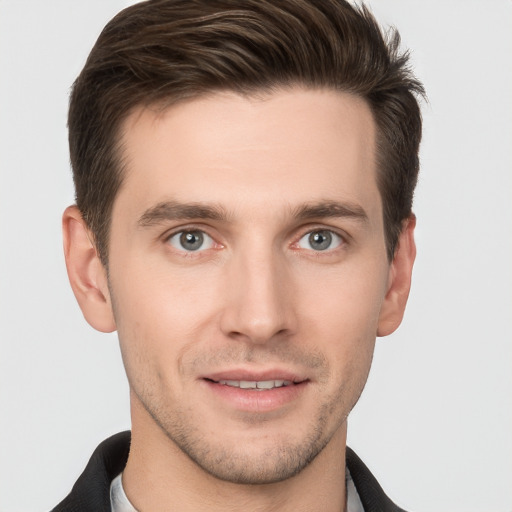 Joyful white young-adult male with short  brown hair and grey eyes