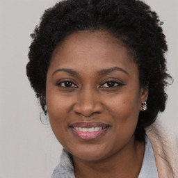 Joyful black adult female with long  brown hair and brown eyes