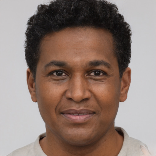 Joyful black adult male with short  brown hair and brown eyes