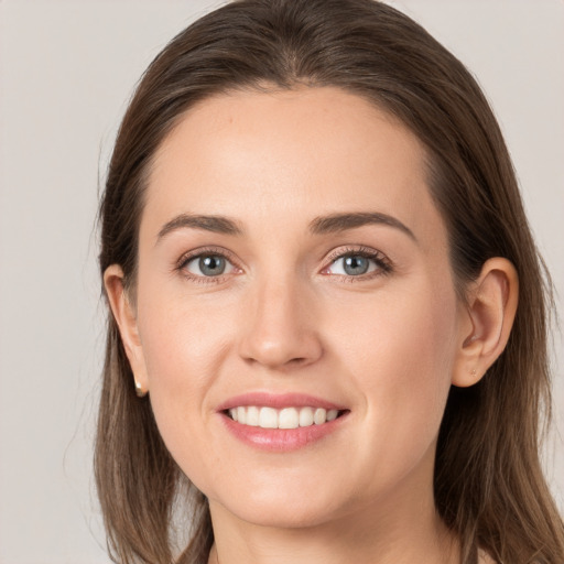 Joyful white young-adult female with long  brown hair and grey eyes