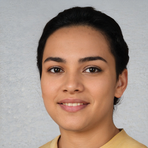 Joyful latino young-adult female with short  black hair and brown eyes