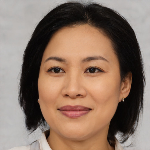 Joyful asian adult female with medium  brown hair and brown eyes