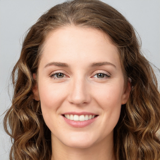 Joyful white young-adult female with long  brown hair and green eyes