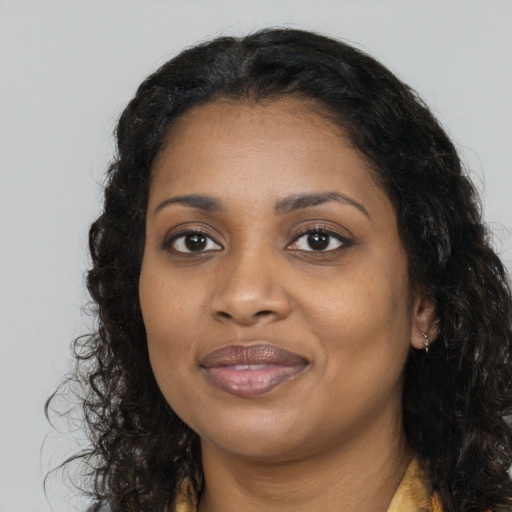 Joyful black young-adult female with long  black hair and brown eyes