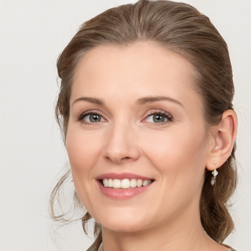 Joyful white young-adult female with medium  brown hair and grey eyes