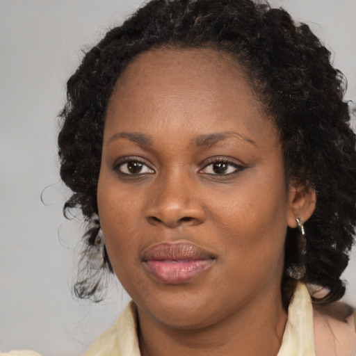 Joyful black young-adult female with medium  brown hair and brown eyes
