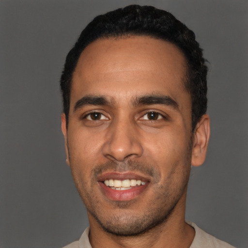 Joyful black young-adult male with short  black hair and brown eyes