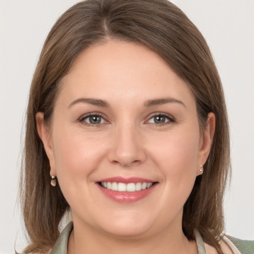 Joyful white young-adult female with medium  brown hair and grey eyes