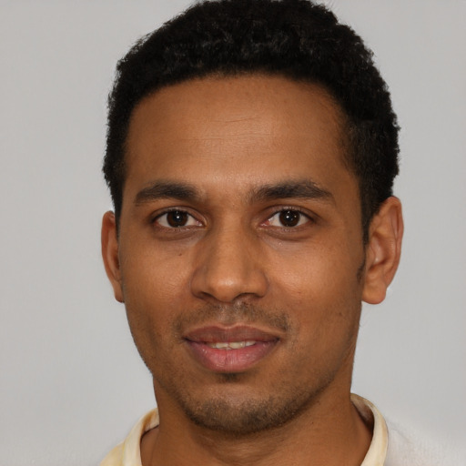 Joyful black young-adult male with short  black hair and brown eyes
