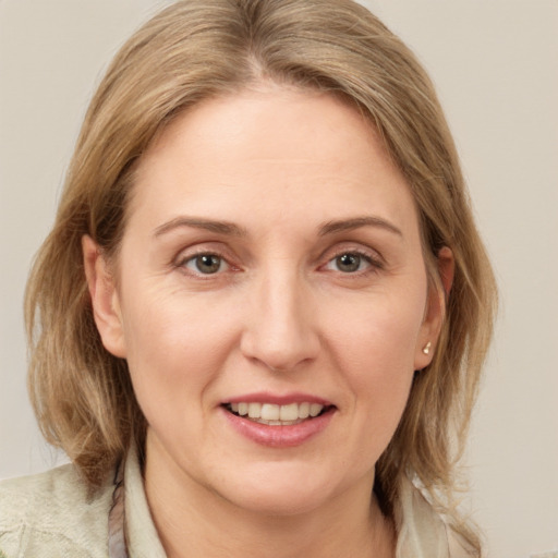 Joyful white adult female with medium  brown hair and grey eyes