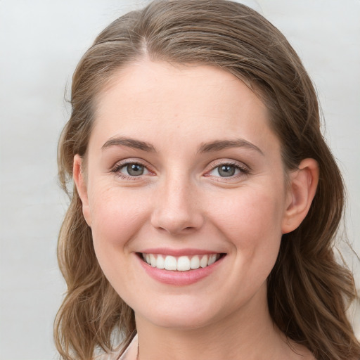 Joyful white young-adult female with long  brown hair and blue eyes