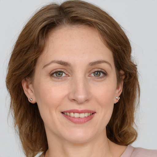 Joyful white young-adult female with medium  brown hair and green eyes