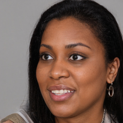 Joyful black young-adult female with long  black hair and brown eyes