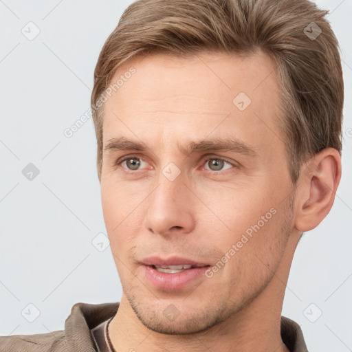 Joyful white young-adult male with short  brown hair and grey eyes