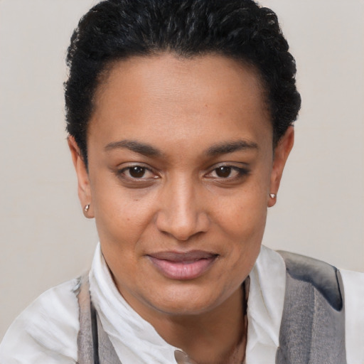 Joyful black young-adult female with short  black hair and brown eyes
