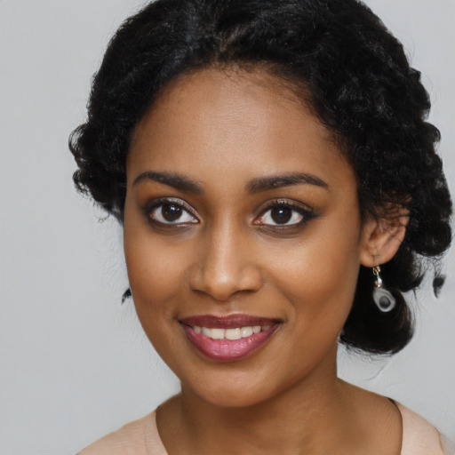 Joyful black young-adult female with long  black hair and brown eyes