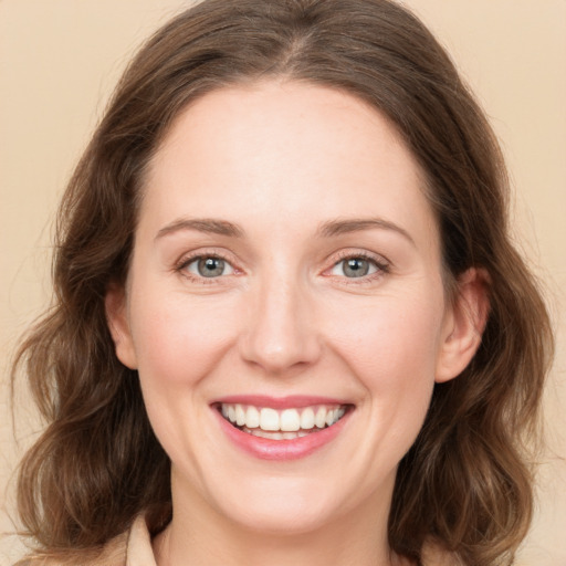 Joyful white young-adult female with medium  brown hair and green eyes