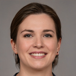 Joyful white young-adult female with medium  brown hair and grey eyes