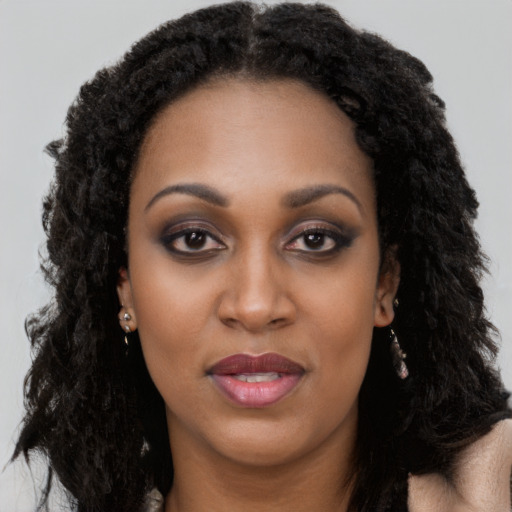 Joyful black young-adult female with long  black hair and brown eyes