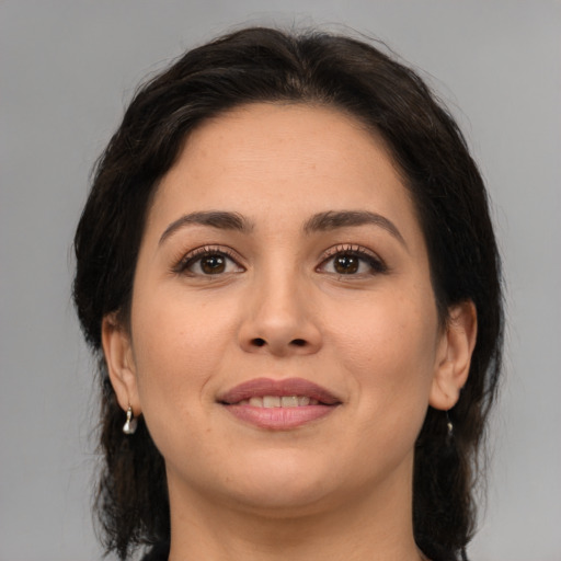 Joyful latino young-adult female with medium  brown hair and brown eyes