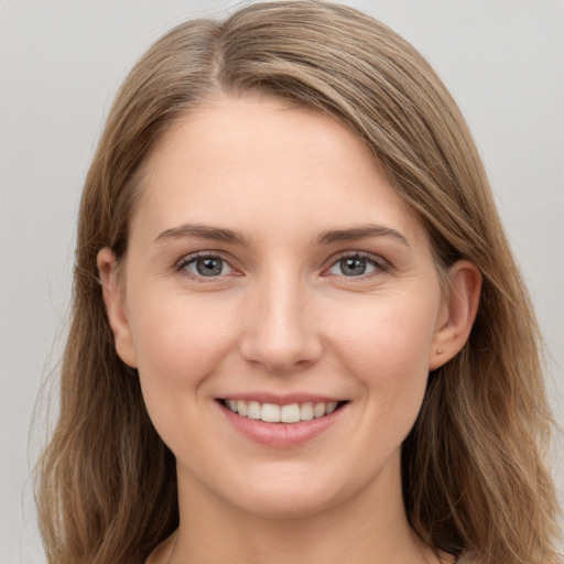 Joyful white young-adult female with long  brown hair and grey eyes