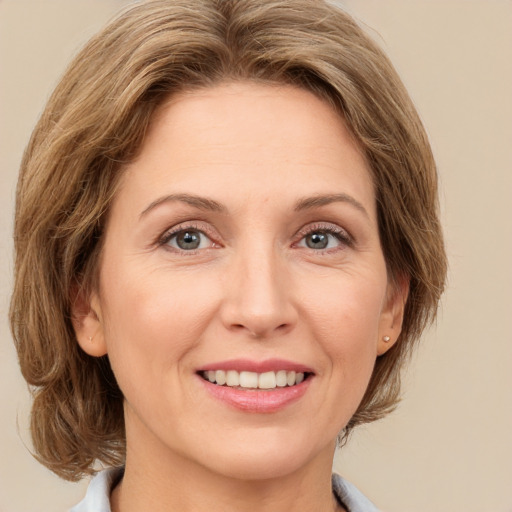 Joyful white adult female with medium  brown hair and green eyes