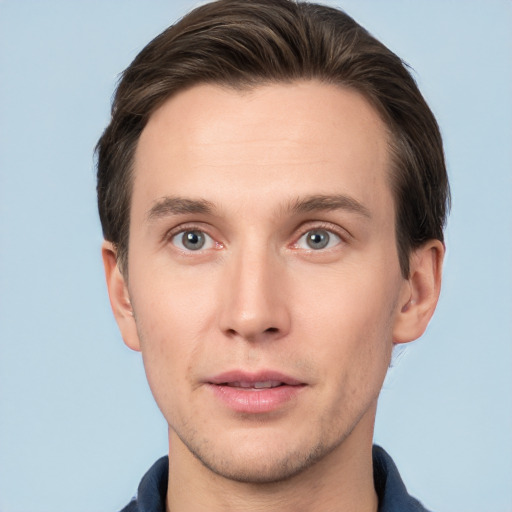 Joyful white young-adult male with short  brown hair and grey eyes