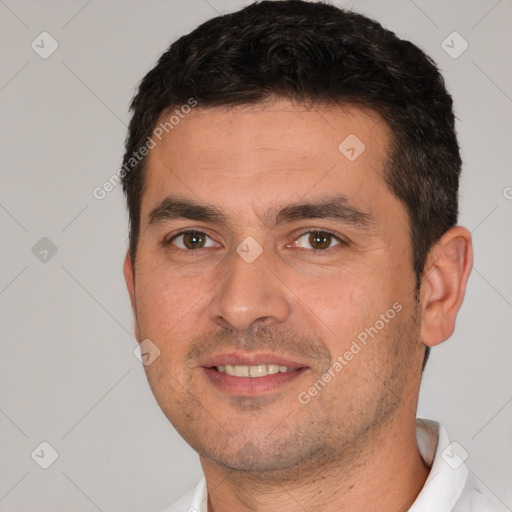 Joyful white young-adult male with short  black hair and brown eyes