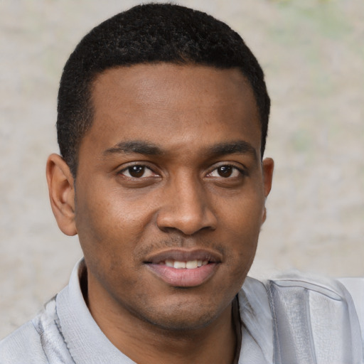 Joyful black young-adult male with short  black hair and brown eyes