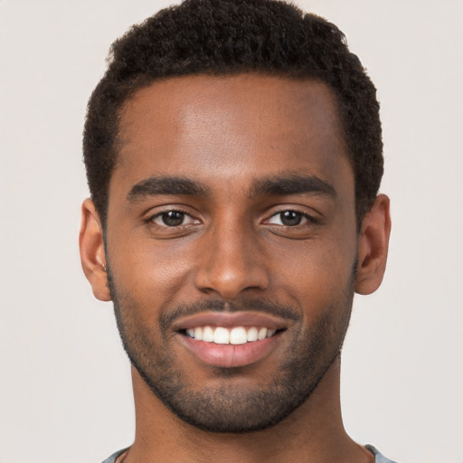 Joyful black young-adult male with short  brown hair and brown eyes