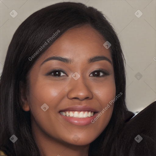 Joyful black young-adult female with long  brown hair and brown eyes