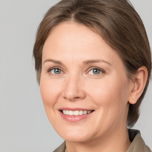 Joyful white adult female with medium  brown hair and grey eyes