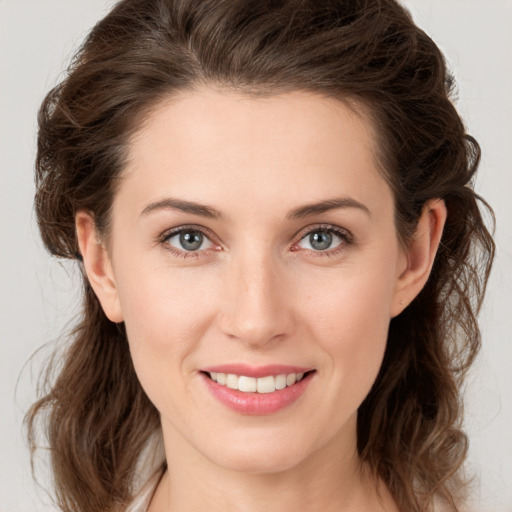 Joyful white young-adult female with medium  brown hair and green eyes