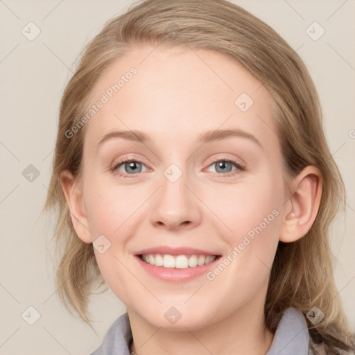 Joyful white young-adult female with medium  brown hair and blue eyes