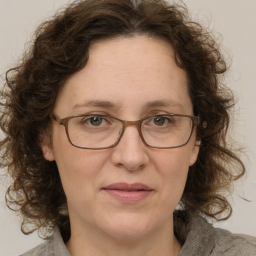 Joyful white adult female with medium  brown hair and blue eyes