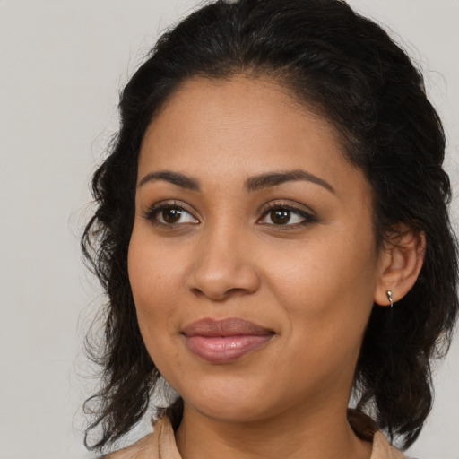 Joyful latino young-adult female with medium  brown hair and brown eyes