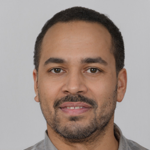 Joyful latino adult male with short  black hair and brown eyes