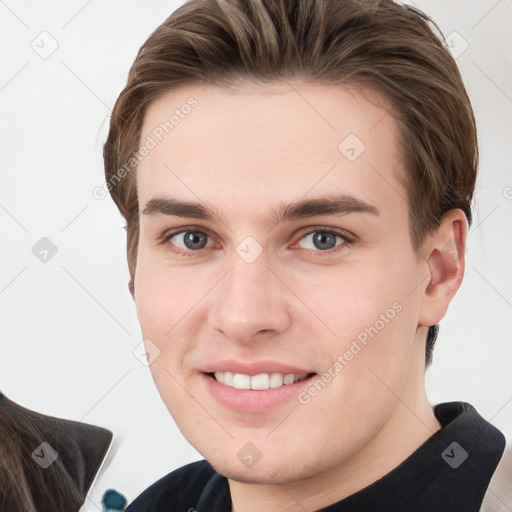 Joyful white young-adult male with short  brown hair and grey eyes