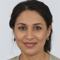 Joyful latino adult female with medium  brown hair and brown eyes