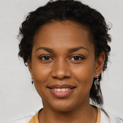 Joyful black young-adult female with short  brown hair and brown eyes