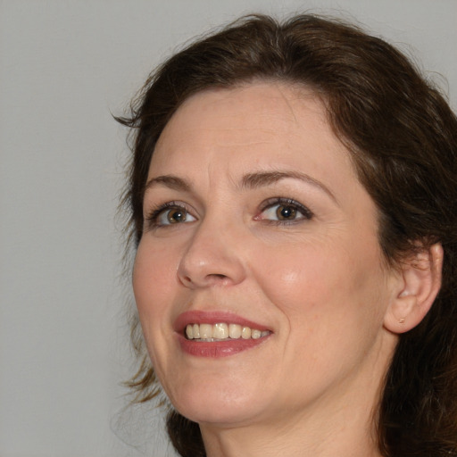 Joyful white adult female with medium  brown hair and green eyes