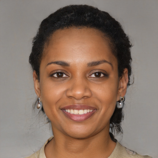 Joyful black young-adult female with short  black hair and brown eyes