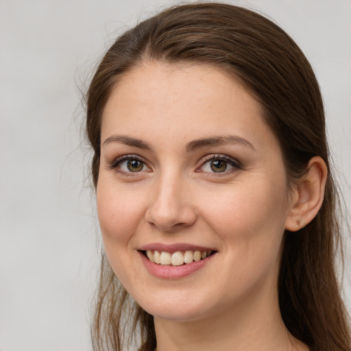 Joyful white young-adult female with long  brown hair and grey eyes