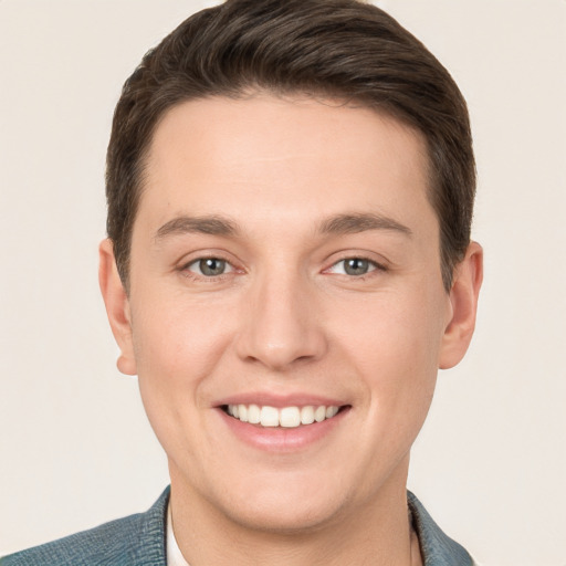 Joyful white young-adult male with short  brown hair and grey eyes