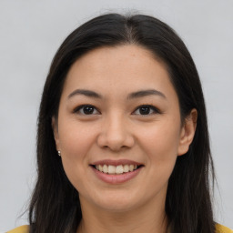 Joyful latino young-adult female with long  brown hair and brown eyes