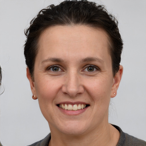 Joyful white adult female with short  brown hair and grey eyes