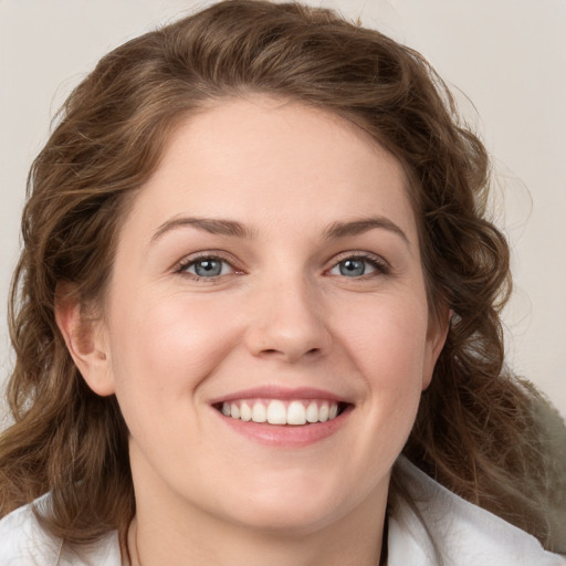 Joyful white young-adult female with medium  brown hair and green eyes