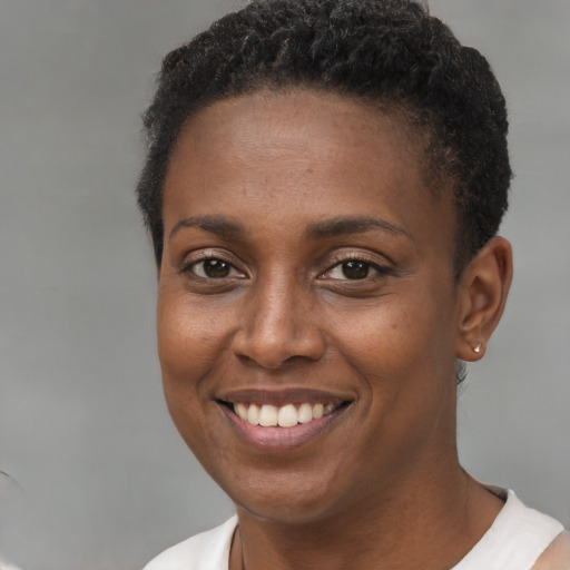 Joyful black young-adult female with short  brown hair and brown eyes