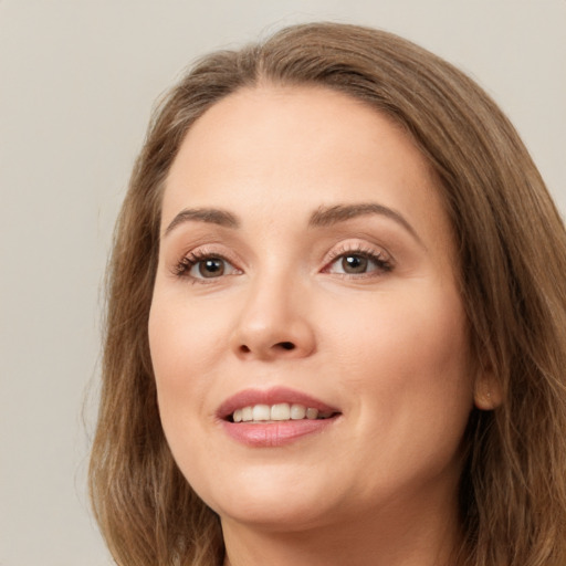 Joyful white young-adult female with long  brown hair and green eyes